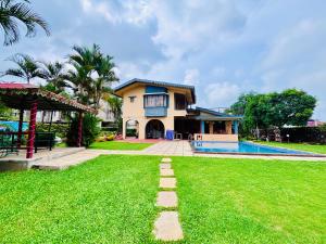 a house with a yard and a swimming pool at Bailey's Castle Villa in Lonavala