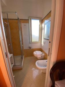 ein Badezimmer mit Dusche, Toilette und Waschbecken in der Unterkunft Orion Accomodation in Tropea