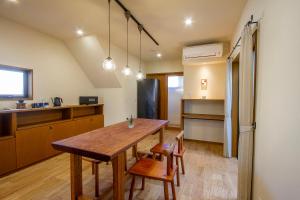 出云市女性専用お宿にこに的房间里有一张桌子和几把椅子的厨房