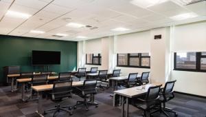 a classroom with tables and chairs and a flat screen tv at Motto by Hilton Philadelphia Rittenhouse Square in Philadelphia