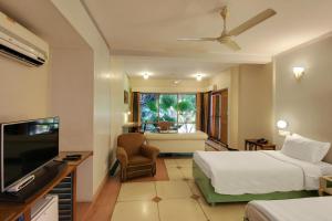 a hotel room with two beds and a television at Hotel Inn Season - Art Deco Heritage Hotel in Jodhpur in Jodhpur