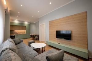 a living room with a couch and a flat screen tv at Regal Luxury Apartments in Sarandë