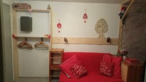 a living room with a red couch and red pillows at Cocooning in Les Rousses