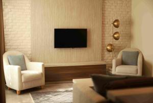 a living room with two chairs and a flat screen tv at Loft 1502 in Antalya