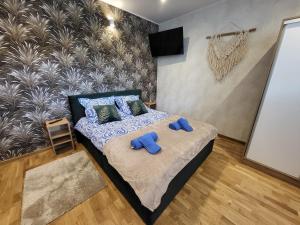 a bedroom with a bed with blue slippers on it at Zatoka Apartamenty in Władysławowo