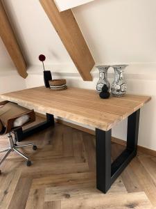 UbbergenにあるLuxe Penthouse nabij Nijmegenの木製テーブル(花瓶付)