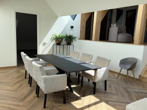 UbbergenにあるLuxe Penthouse nabij Nijmegenの黒いテーブルと椅子のあるダイニングルーム