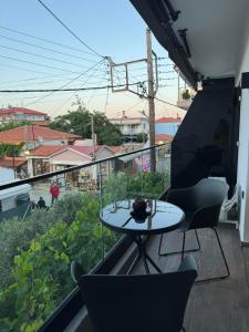 a patio with a table and chairs on a balcony at sarti luxury diaMoNd in Sarti +2 photos