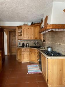 a kitchen with wooden cabinets and a stove top oven at Casa Auroranna in Sappada