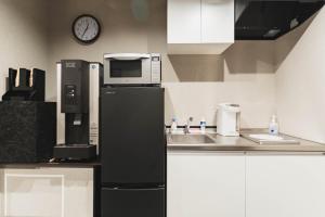 a kitchen with a microwave on top of a refrigerator at Laon Inn Miyakojima in Miyako-jima