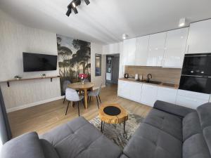 a living room with a couch and a table at Zatoka Apartamenty in Władysławowo