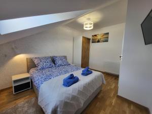 a bedroom with a bed with blue towels on it at Zatoka Apartamenty in Władysławowo