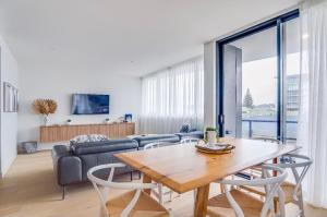 a living room with a table and a couch at Luxury Palm Beach Getaway in Gold Coast