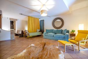a living room with a blue couch and chairs at Il Nido dell'Oca - Loft Giardino in Siena
