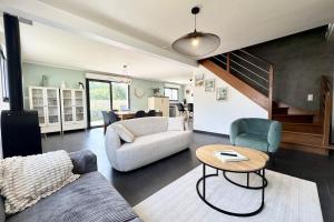 un salon avec un canapé et une table dans l'établissement Belle maison contemporaine aux portes de Lorient, à Kervignac