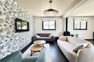 un salon avec un canapé et une table dans l'établissement Belle maison contemporaine aux portes de Lorient, à Kervignac