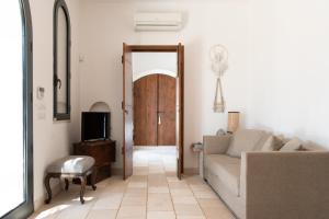 a living room with a couch and a tv at Cisternino Villa in Olive Groove in Cisternino