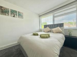 a bedroom with a large bed with two teddy bears on it at Long Term Comfort - 2BR Haven in Cheshunt