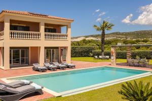 a villa with a swimming pool and a house at Villa Sunset in Argostoli