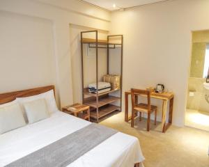 圣胡安Frania Boutique Hotel的一间卧室，配有一张床、一张桌子和一把椅子