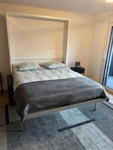 een bed met twee kussens erop in een slaapkamer bij Deux pas du lac & Centre de Montreux in Veytaux