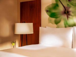 a bed with a white pillow and a lamp at Fairmont Chicago Millennium Park in Chicago