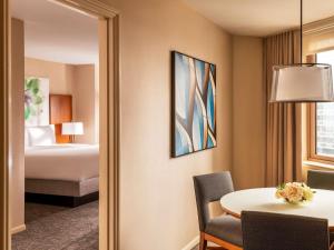 a hotel room with a bed and a table and a room at Fairmont Chicago Millennium Park in Chicago