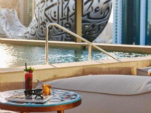a table with a drink on top of a pool at 25hours Hotel Dubai One Central in Dubai