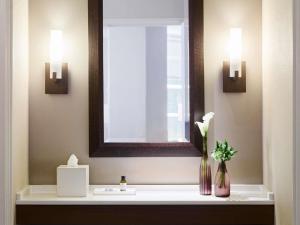 a bathroom with a sink with a mirror and a vase of flowers at Fairmont Chicago Millennium Park in Chicago