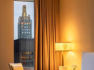 a hotel room with a window with a view of a skyscraper at Fairmont Chicago Millennium Park in Chicago