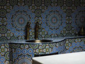 a bathroom with a sink with a blue and gold wallpaper at 25hours Hotel Dubai One Central in Dubai