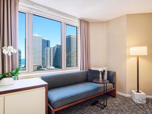 a living room with a couch and a large window at Fairmont Chicago Millennium Park in Chicago