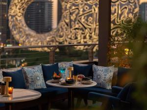 a table with plates of food on a couch on a balcony at 25hours Hotel Dubai One Central in Dubai