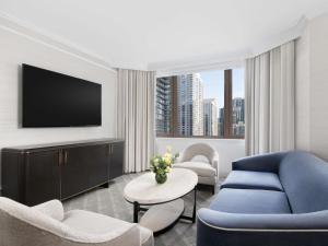 a living room with a blue couch and a tv at Fairmont Chicago Millennium Park in Chicago