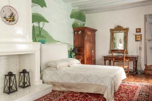 a bedroom with a bed and a fireplace at La Maison Charmante in Châtellerault