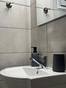 a white sink in a bathroom with a mirror at The Chalkida Nook Central Spot in Chalkida
