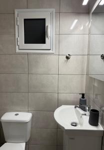 a bathroom with a toilet and a tv on the wall at The Chalkida Nook Central Spot in Chalkida +14 photos