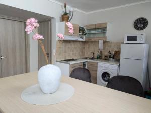a vase with flowers on a table in a kitchen at Loutraki central studio in Loutraki