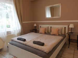 a bedroom with a bed with two pillows on it at Éden Villa - Family Apartmanok in Balatonfüred