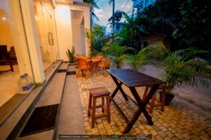 a wooden table and chairs on a patio at BLUE WHALES HOTEL in Hikkaduwa