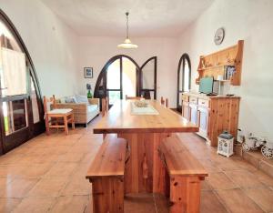 a kitchen with a large wooden table and benches at Villa Rosa Bestvacationever in Torre delle Stelle