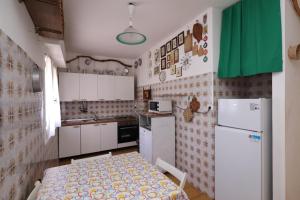 a small kitchen with a table and a refrigerator at Brorent Casa Maria in Platamona +10 photos