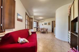 ein Wohnzimmer mit einem roten Sofa und einem Esszimmer in der Unterkunft Chiara's flat in Laiatico