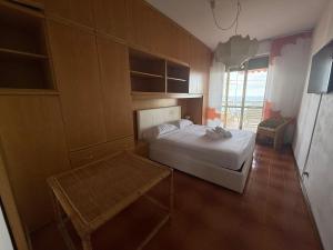 a small bedroom with a bed and a table at Suite Panorama - Sanremo in Sanremo