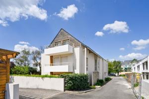 a white house on a street with a fence at L'Appart du Marché - A quelques min de la plage in Pornichet