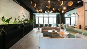 a restaurant with couches and a table and chairs at VacationClub - Green Port Apartament 506 in Kołobrzeg