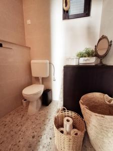 a bathroom with a toilet and baskets and a mirror at CasaCalla in Okrug Donji +18 photos