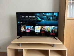 a flat screen tv sitting on top of a wooden stand at Ferienwohnung mit vollausgestatteter Küche - SmartTV I Free Netflix I 24h Check in in Bielefeld