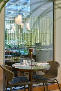 a table and chairs in a restaurant with a window at Golden Residence Hotel in Funchal