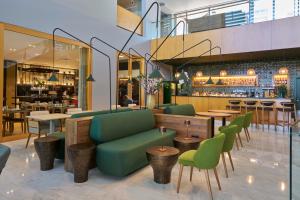 a restaurant with green chairs and tables and a bar at Golden Residence Hotel in Funchal